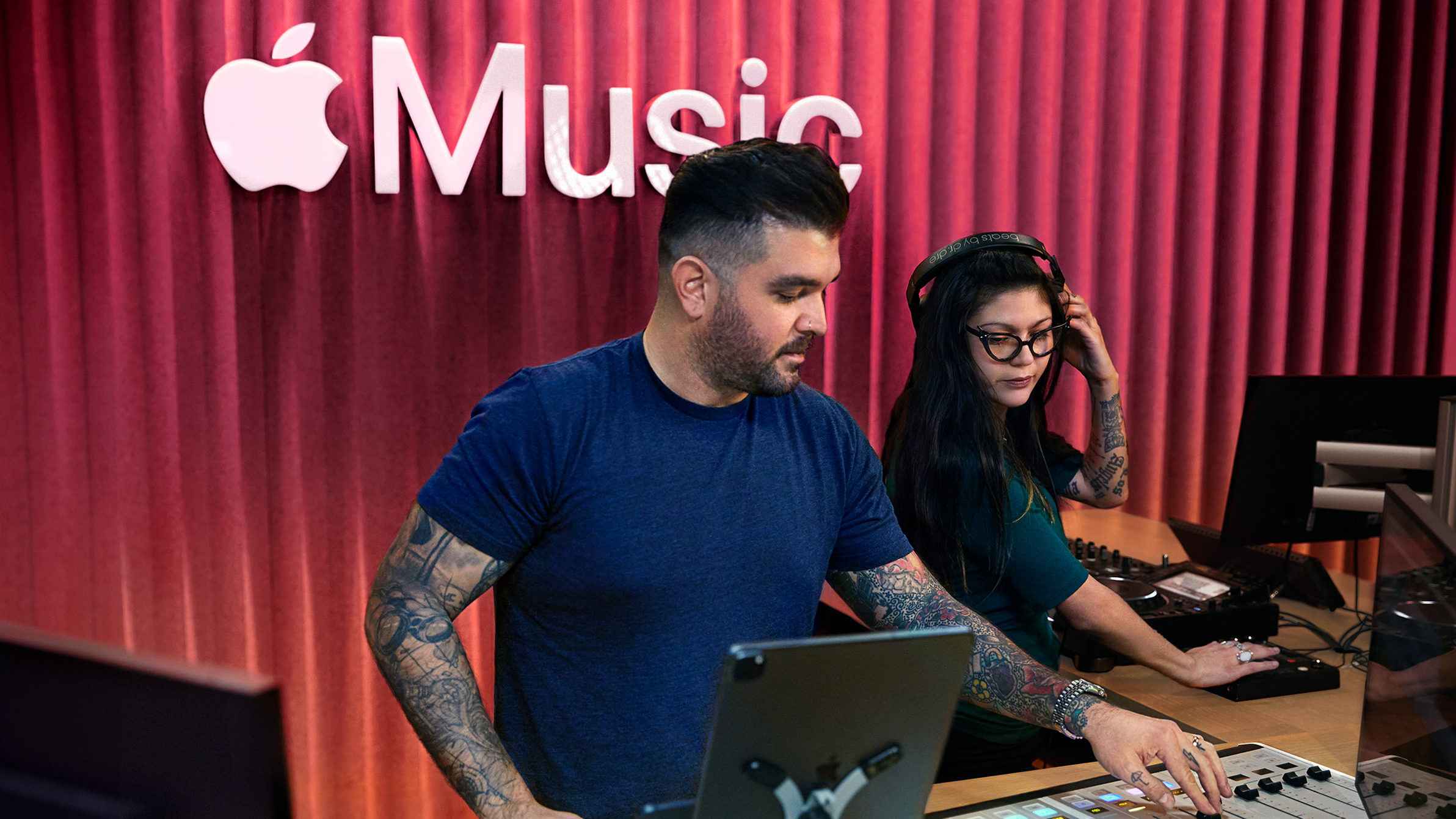 兩位 Apple 同事在 Apple Music 錄音室中使用混音板。