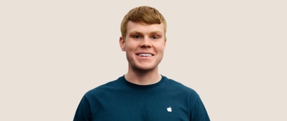 Portr?t eines l?chelnden Apple Retail Teammitglieds mit kurzen dunkelblonden Haaren.