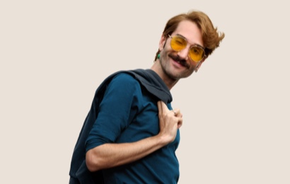 Portr?t eines l?chelnden Apple Retail Teammitglieds mit kurzen dunkelblonden Haaren und Brille.
