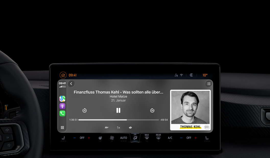 Ein Autointerieur, das Display der Mittelkonsole zeigt Apple Podcasts, die über CarPlay wiedergegeben werden, es l?uft der Podcast ?The Spark of Life“ von Radiolab, die Wiedergabesteuerung umfasst Zurück, Pausieren und Vorw?rts.