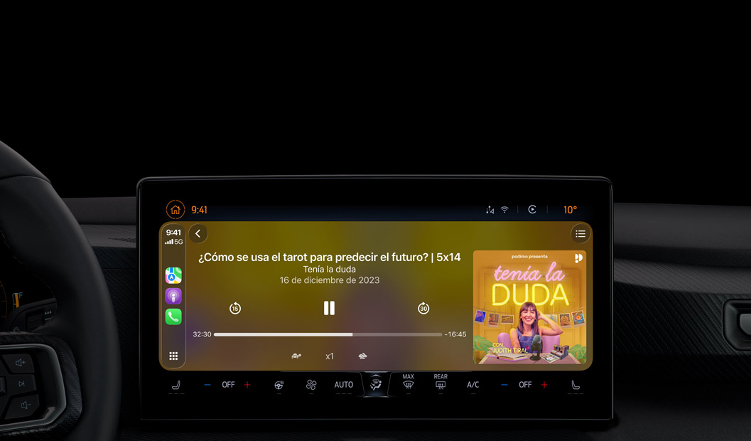 Interior de un coche, la pantalla de la consola central muestra Apple Podcasts reproduciéndose a través de CarPlay, se está reproduciendo el podcast ?The Spark of Life? de Radiolab, aparecen los controles de reproducción para retroceder, pausar y avanzar.