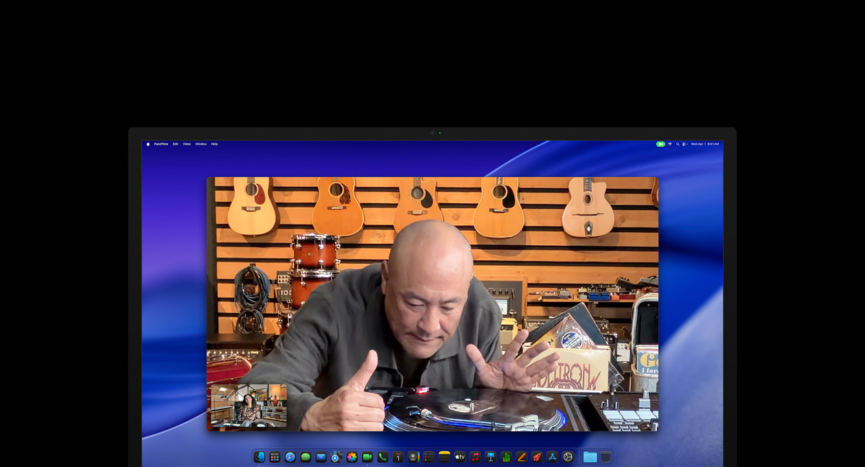 Une personne passant un appel vidéo dans un magasin de musique regarde attentivement une platine, elle reste au centre de l’image grace à la caméra Center Stage