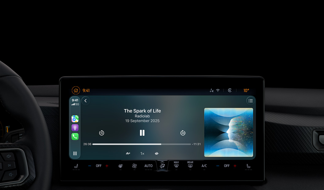 汽車內(nèi)部，中央控制臺(tái)顯示器顯示 Apple Podcast 透過(guò) CarPlay 播放，正在播放 Radiolab 的 podcast《The Spark of Life》，播放控制項(xiàng)目包括倒轉(zhuǎn)、暫停和快轉(zhuǎn)。