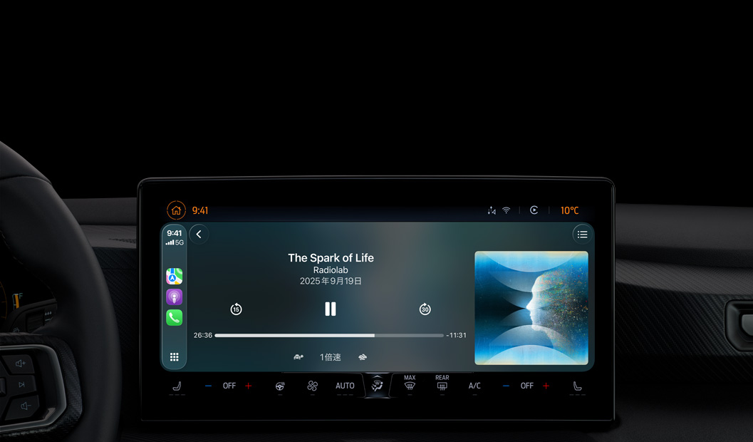 車(chē)の內(nèi)部、センターコンソールのディスプレイにCarPlay経由でApple Podcastの再生が表示されている。Radiolabの「The Spark of Life」のポッドキャストが現(xiàn)在再生されており、再生コントロールには早戻し、一時(shí)停止、スキップがある