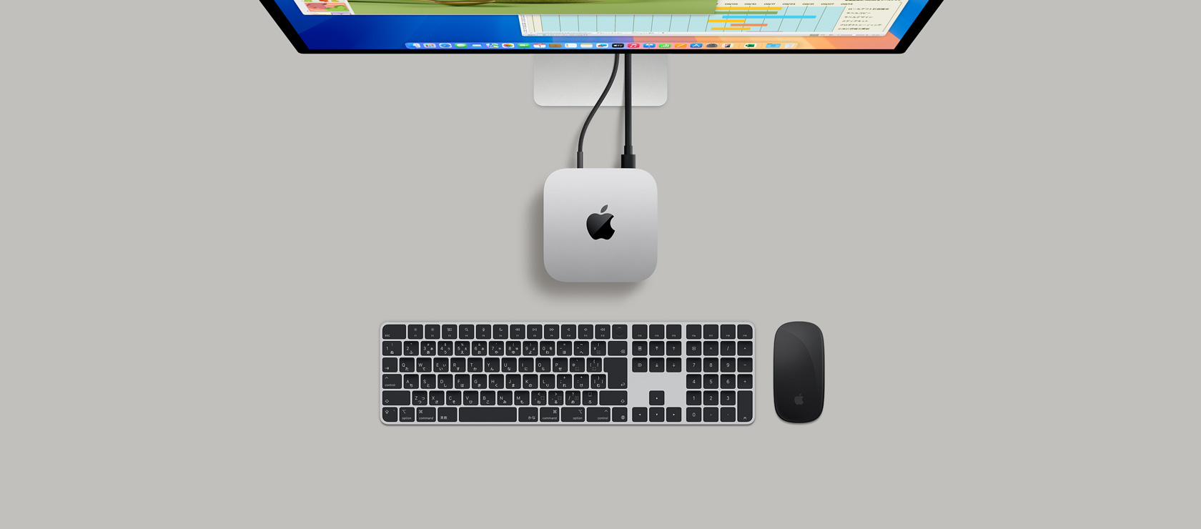 ディスプレイにつながれたシルバーのMac miniを上から見(jiàn)た図。ディスプレイにはKeynoteとMicrosoft Excelのウインドウが表示されている
