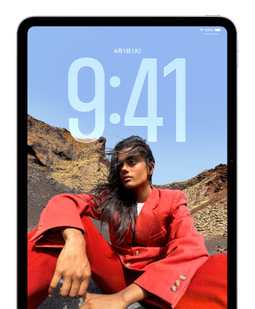 iPadのロック畫面。座っている人物の寫真の後ろに時刻を示す數(shù)字が大きく表示されている