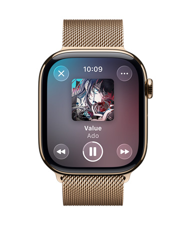 ミラネーゼループバンドを組み合わせたゴールドチタニウムのApple Watch。畫面には再生中のApple Musicと、半透明なLiquid Glassのコントロールが表示されている
