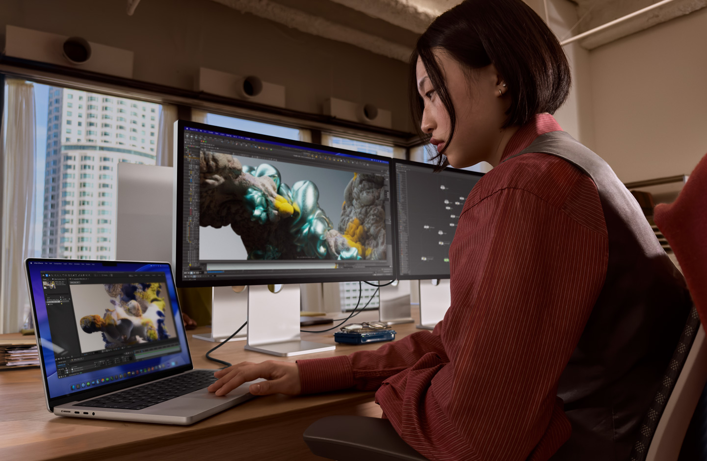 オフィスでMacBookノートブックを使って作業(yè)している人物。Thunderbolt 5ポートでStudio Display XDRに接続している