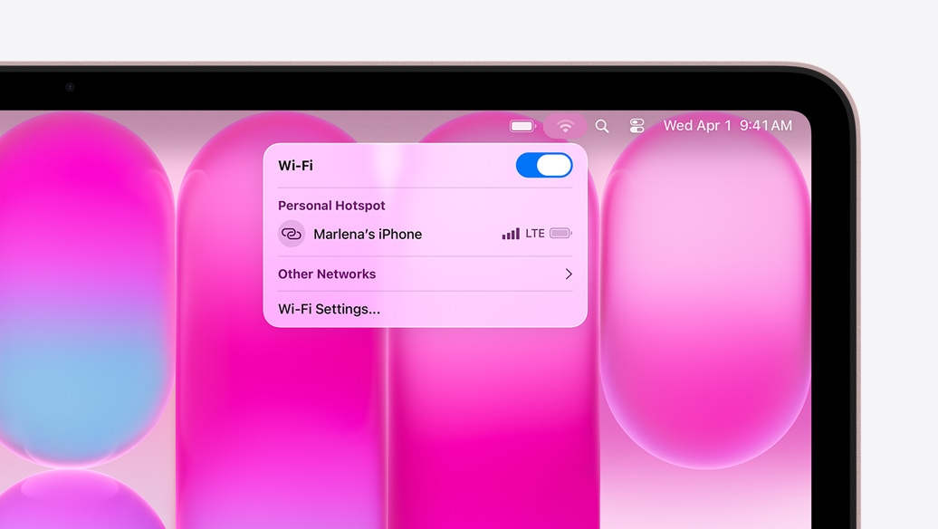MacBook Neo w kolorze subtelnego ró?u, w menu Wi-Fi wida? sekcj? Hotspot osobisty z opcj? wyboru ?iPhone Marleny”