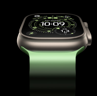 Siyah arka plan üzerinde Natürel Titanyum Apple Watch Ultra 3’ün yak?n ?ekim g?rüntüsü. Ekranda saat ve di?er dinamik bilgiler g?rünüyor.