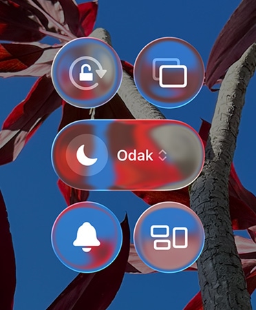 Renkli iPhone Ana Ekran?’nda ?effaf Liquid Glass, uygulamalar ve ara? tak?mlar? g?steriliyor