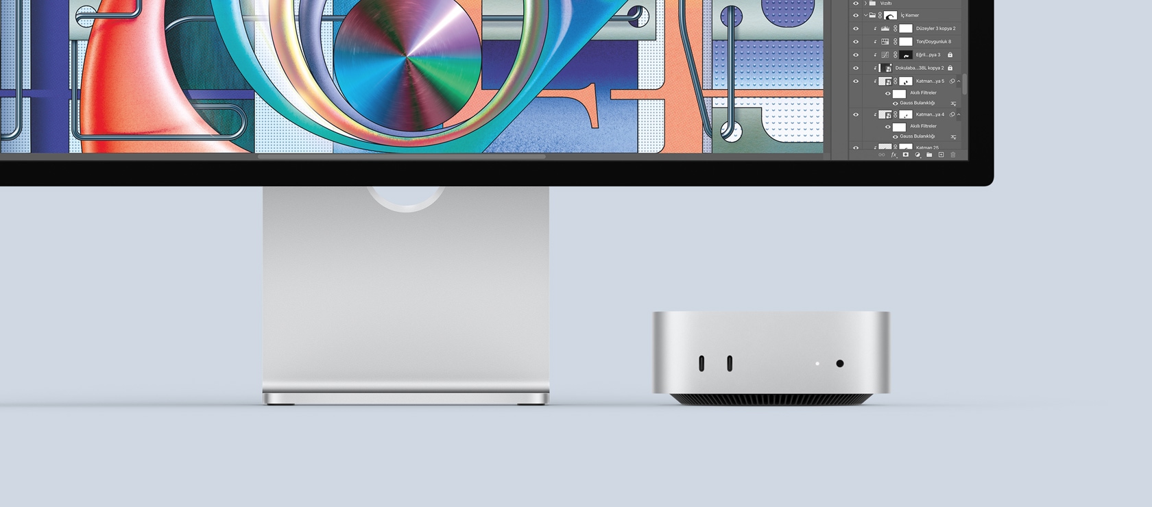 Gümü? rengi Mac mini’nin ?n ba?lant? noktalar?n? ve g?sterge ?????n? g?steren ?nden g?rünümü, renkli bir ekran?n a??k oldu?u Mac monit?rün alt?na nas?l kolayca s??d??? g?steriliyor