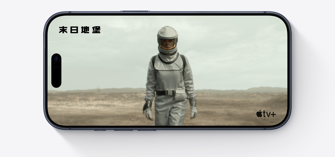 橫放的 iPhone 機身正面，展示 Apple TV+ 影集《末日地堡》的剪輯片段，畫面中的人身穿太空服
