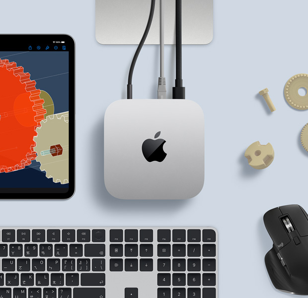 擺放在桌面的銀色 Mac mini 俯視圖，旁邊放著黑色配銀色的無線鍵盤、黑色無線滑鼠和一部 iPad