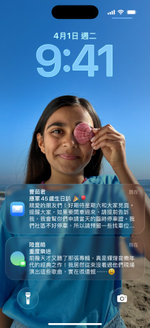 五款層疊的 iPhone 機(jī)型微微展開，每款機(jī)型彼此略微重疊。最左側(cè)的螢?zāi)徽故居嵪?app 中設(shè)有背景的對(duì)話；左側(cè)第二個(gè)螢?zāi)徽故局鳟嬅?，其中包含色彩繽紛的 app 圖像；中間的機(jī)型展示鎖定畫面，其中包含照片、呈現(xiàn)時(shí)間的 Liquid Glass 數(shù)字設(shè)計(jì)，以及兩則顯示在螢?zāi)坏撞康耐ㄖ挥覀?cè)第二款機(jī)型展示 Liquid Glass 設(shè)計(jì)的透明 app 圖像；最右側(cè)的機(jī)型展示 Liquid Glass 設(shè)計(jì)下的音樂播放器