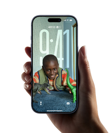 一隻手拿著 iPhone 裝置，展示全新 Liquid Glass 設(shè)計，讓時間顯示隨鎖定畫面上的影像動態(tài)調(diào)整