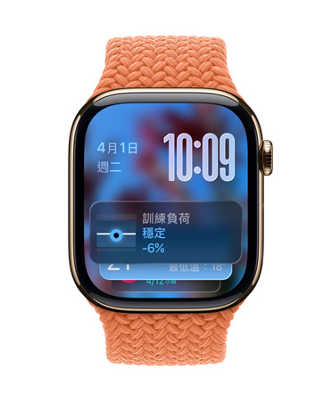 以金色鈦金屬打造的 Apple Watch，搭配橘紅色編織錶帶，錶面左上角顯示日期、右上角顯示以數(shù)字堆疊呈現(xiàn)的時間，底部顯示訓(xùn)練負(fù)荷小工具，都以 Liquid Glass 的半透明風(fēng)格呈現(xiàn)