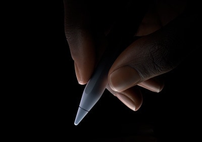 Eine Hand h?lt das untere Drittel des Apple Pencil Pro zwischen Daumen und Zeigefinger in Schreibposition.