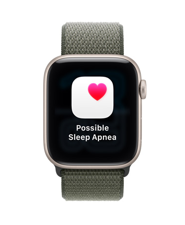 Apple Watch SE 3, aluminiumboett i stj?rnglans, notis om m?jlig s?mnapné, rosa hj?rta i en vit ruta, h?ger utsida, Digital Crown, sportloop i skogsgr?nt