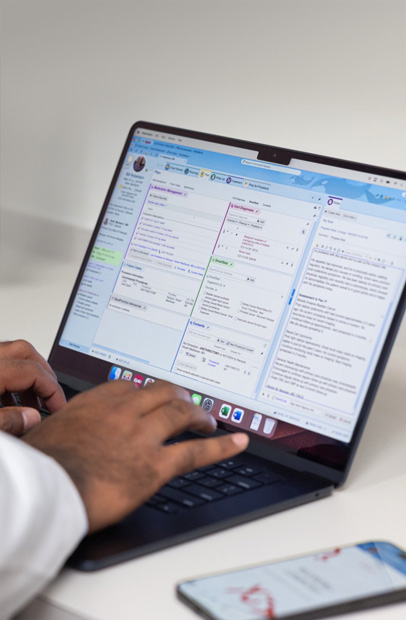 Profissional da saúde consulta registros eletr?nicos de saúde em um MacBook Pro.