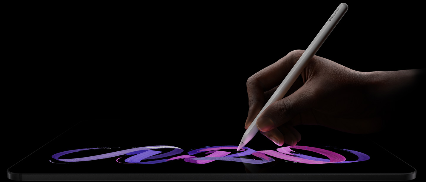 iPad Pro, parte delantera exterior, posición horizontal, perfil lateral, color negro espacial, una mano sostiene un Apple Pencil Pro blanco con el que dibuja un dise?o abstracto púrpura y rosa en la pantalla