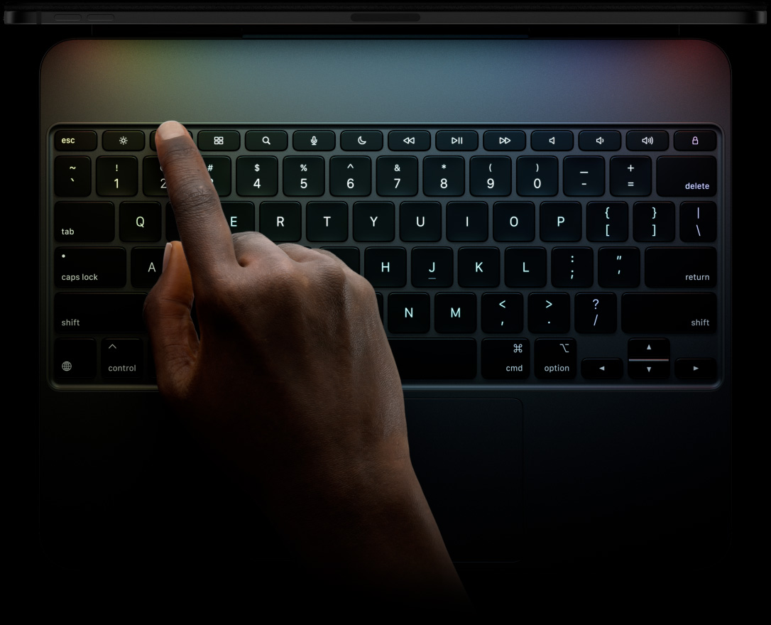 iPad Pro, posición horizontal, color negro espacial, perfil superior, acoplado a un Magic Keyboard, parte delantera exterior, posición horizontal, teclas retroiluminadas en color negro, fila de teclas de función, teclas Escape, Tab, Mayúsculas, Control, Mayúsculas, Eliminar, Intro, teclas de flecha en forma de T invertida