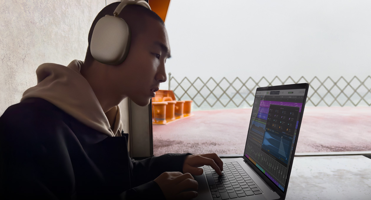 Vista lateral de una persona con unos AirPods Max que usa Logic Pro en un MacBook Pro de 16 pulgadas