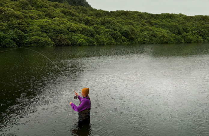 Foto de una mujer pescando con mosca en un río, herramienta de Pixelmator Pro que elimina objetos no deseados