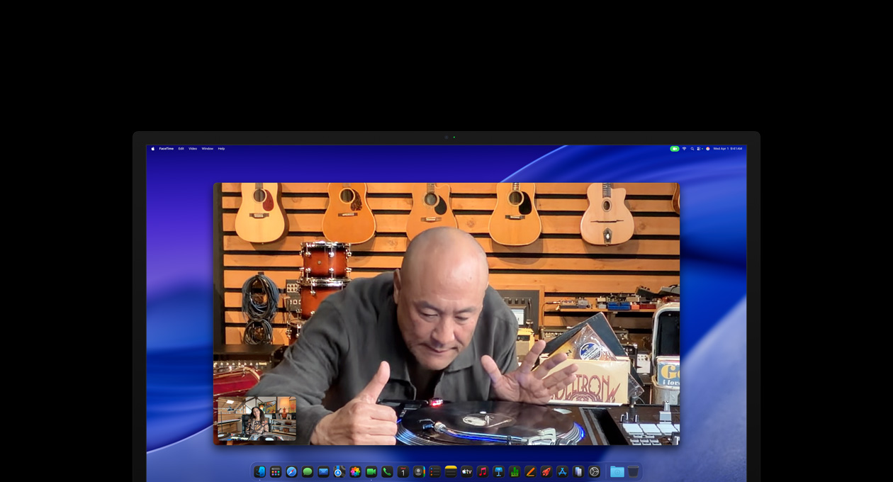 Durante uma chamada de vídeo, uma pessoa em uma loja de música observa um toca-discos e permanece no centro da imagem gra?as à camera Center Stage